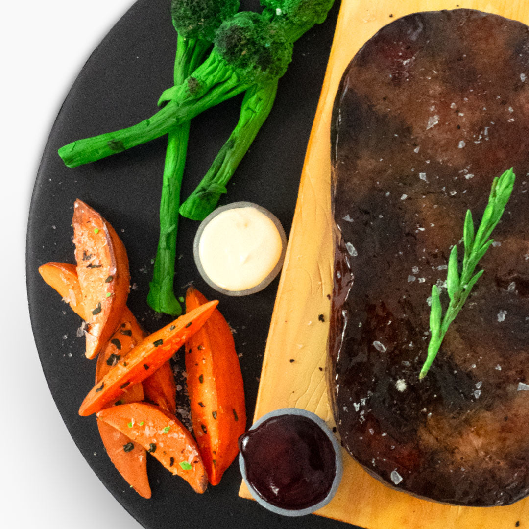 Juicy steak & chips cake! Medium rare quality cake steak with brocolli and sweet potato fries on the side, not forgetting the peppercorn and bearnaise sauces. Displayed on a wooden chopping board also made of cake