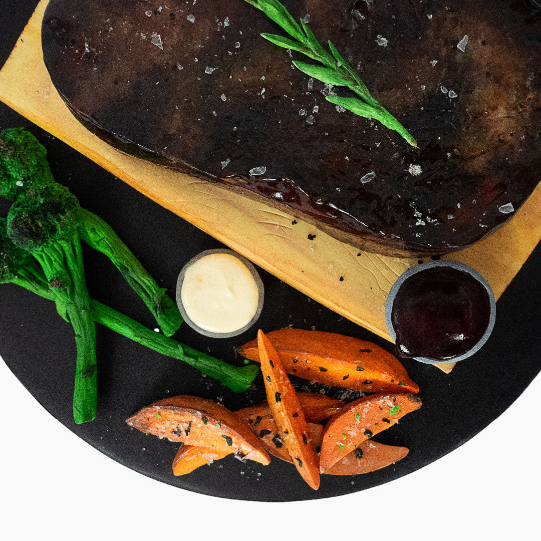 Juicy steak & chips cake! Medium rare quality cake steak with brocolli and sweet potato fries on the side, not forgetting the peppercorn and bearnaise sauces. Displayed on a wooden chopping board also made of cake