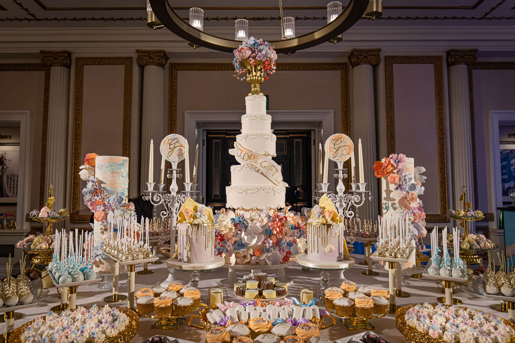 large table displaying a huge spread of luxury indulgent cakes and sweet treats at the kimpton fitzroy global gift gala event
