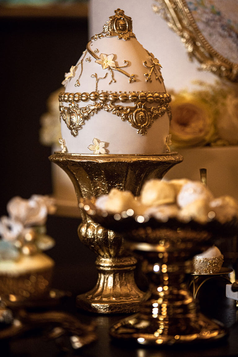 gold and white egg shaped cake at a spread of indulgent treats in the kimpton fitzroy hotel