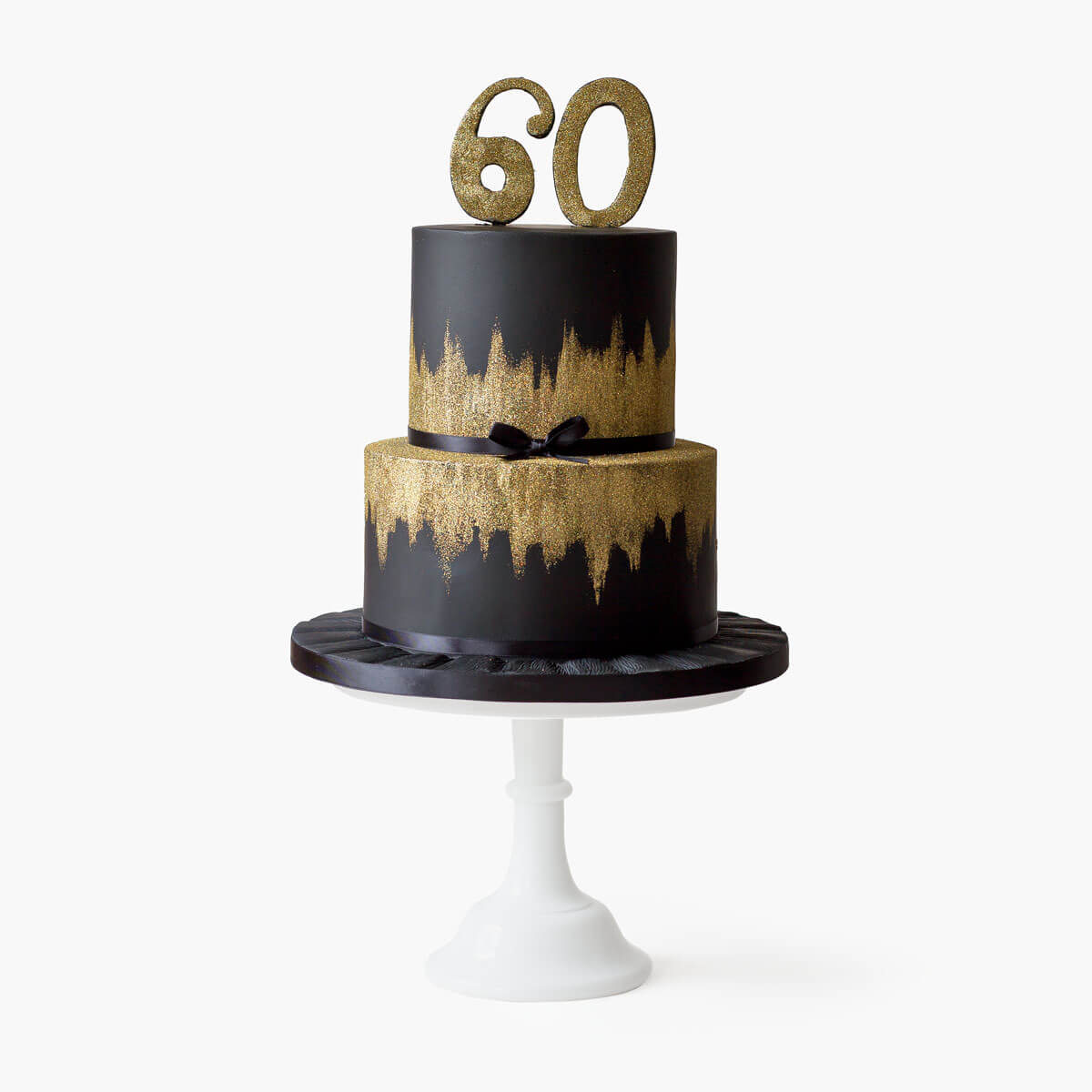 Two tiered black and gold birthday cake with edible gold glitter is perfect for anyone celebrating a milestone birthday. Perfect for 40th, 50th, 60th and 70th birthdays.