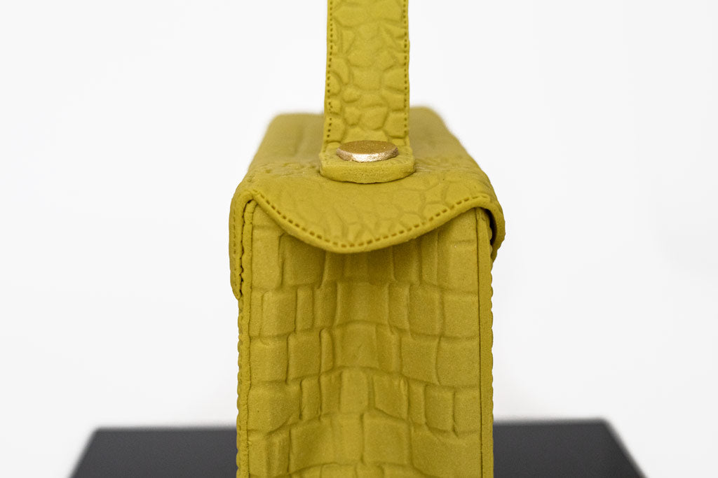 Aspinal of London inspired handbag cake . The "Mayfair Handbag" design is encased in fondant and textured to mimic crocodile leather.