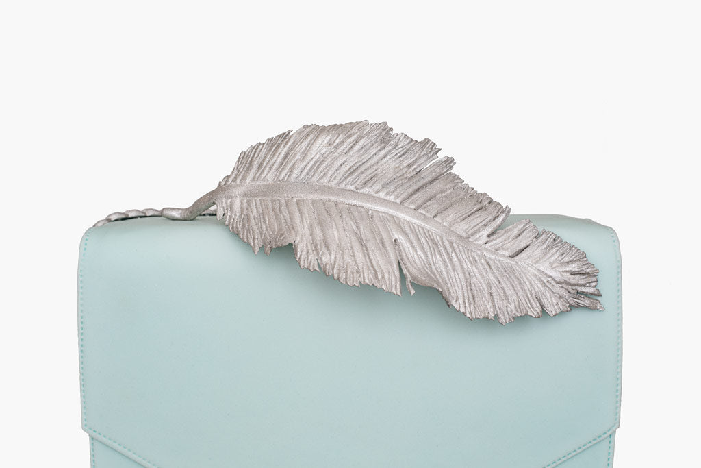 Ralph and Russo inspired leather handbag cake, is an exquisite fusion of elegance and artistry. The handbag cake is wrapped in smooth baby blue fondant and sculpted to emulate fine leather. Complete with Ralph and Russo’s signature metallic feather detail and precise stitching, this cake is a luxurious centrepiece, perfect for those celebrating style and haute couture.