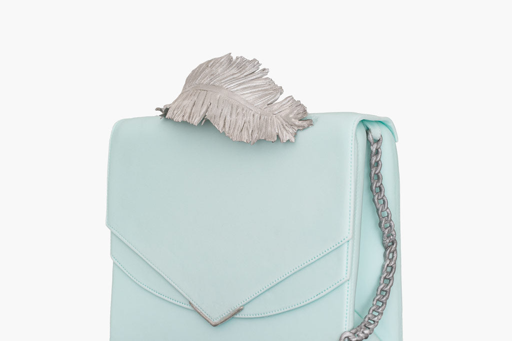 Ralph and Russo inspired leather handbag cake, is an exquisite fusion of elegance and artistry. The handbag cake is wrapped in smooth baby blue fondant and sculpted to emulate fine leather. Complete with Ralph and Russo’s signature metallic feather detail and precise stitching, this cake is a luxurious centrepiece, perfect for those celebrating style and haute couture.