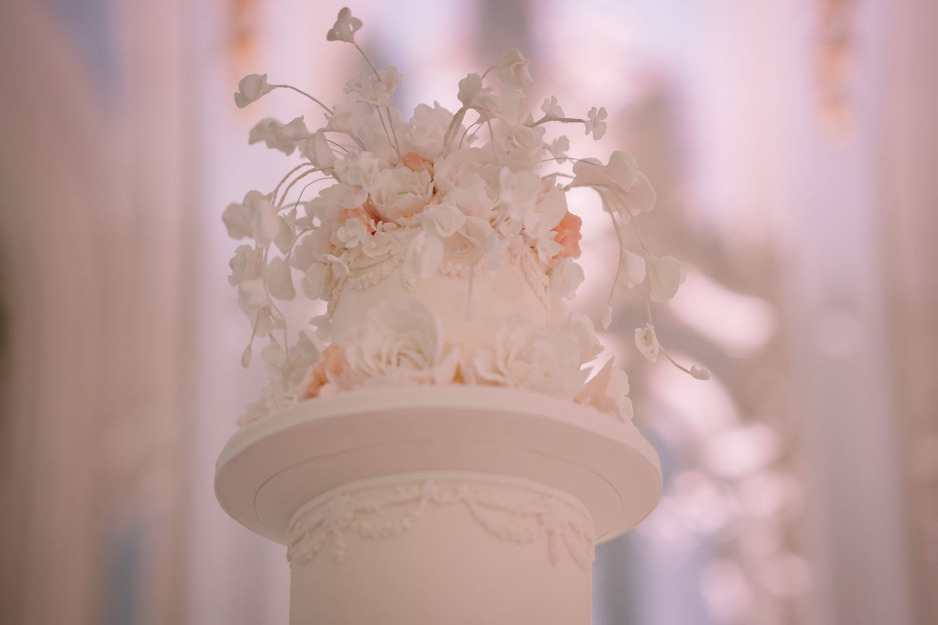 beautiful pale pink wedding cake top tier detailed with white and pink flowers