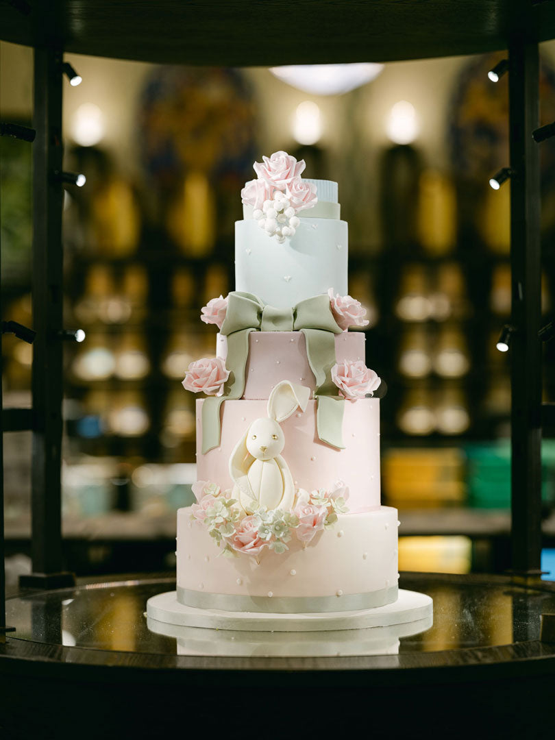 a luxury pastel coloured easter cake in harrods with a bunny, bows and sugar flowers