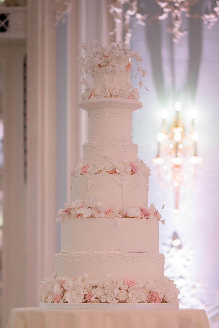 beautiful tall pale pink wedding cake detailed with white and pink flowers at the savoy