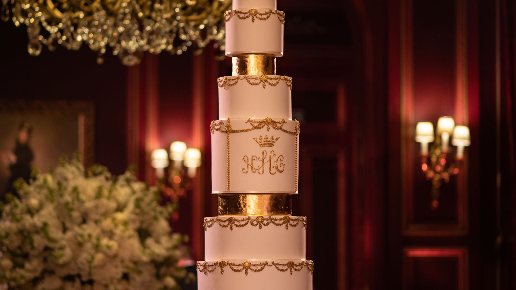 detailed gold icing on a tall wedding cake in a grand room