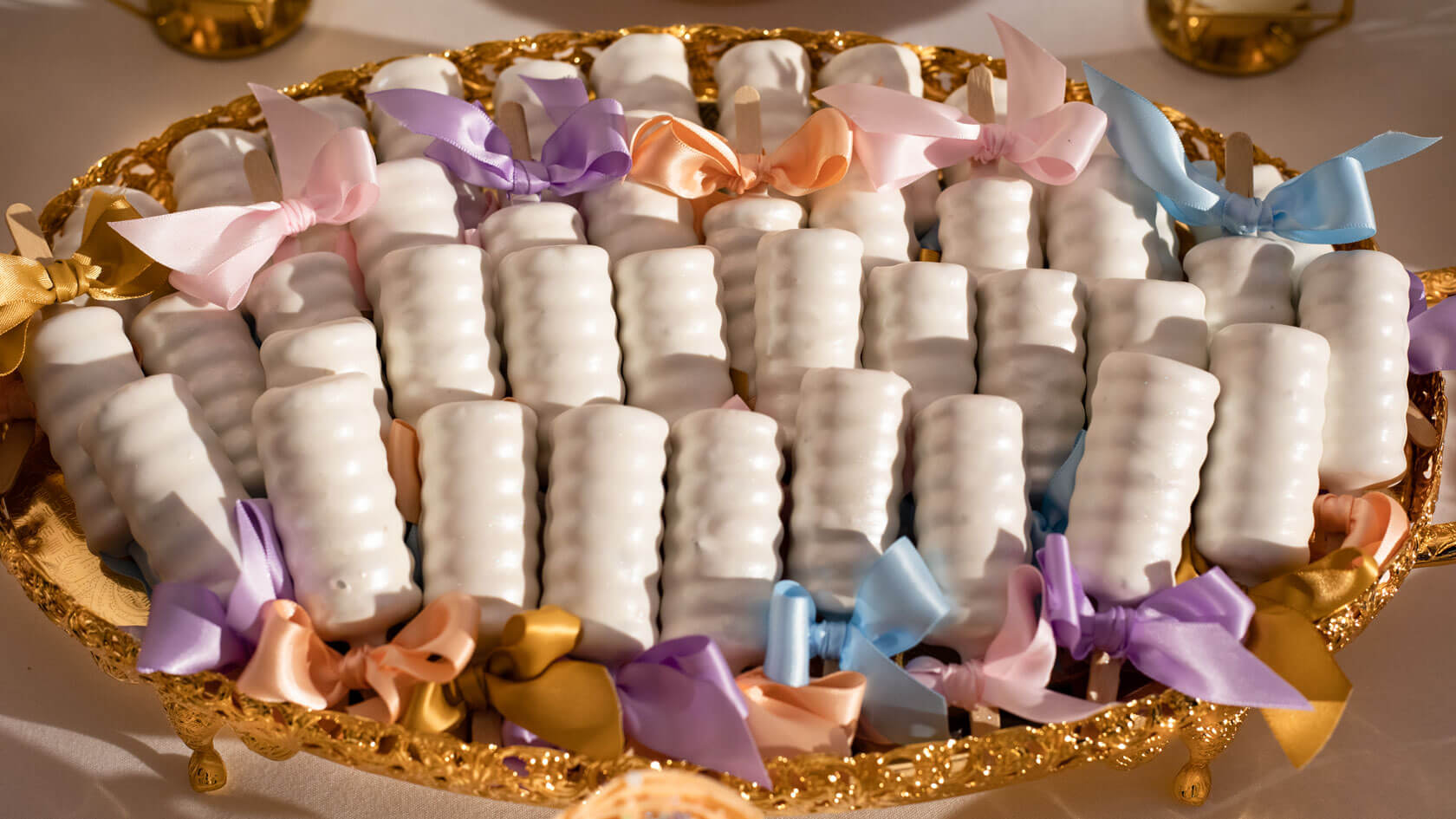 sweet treats with colourful bows in a gold tray