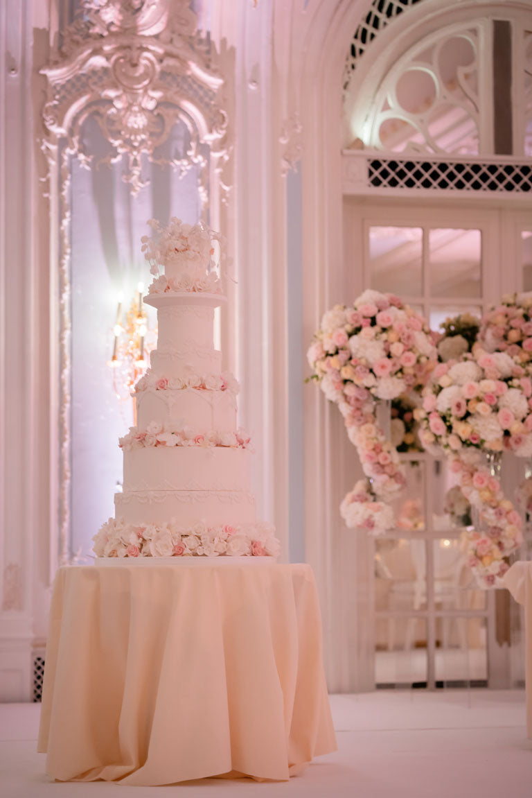 luxury tall pale pink wedding cake on a table in the savoy hotel