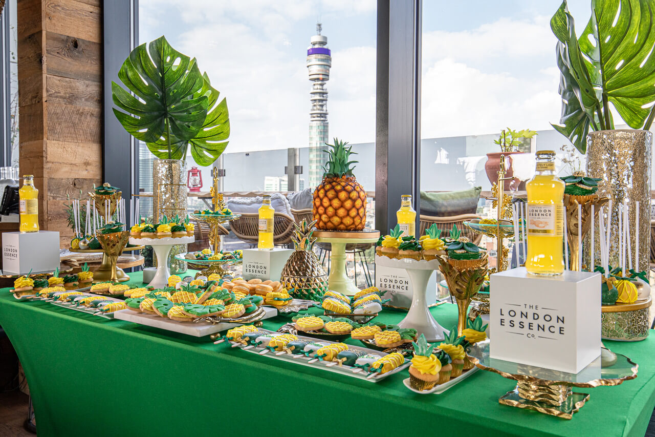 a pineapple themed cake display with london's bt tower in the background