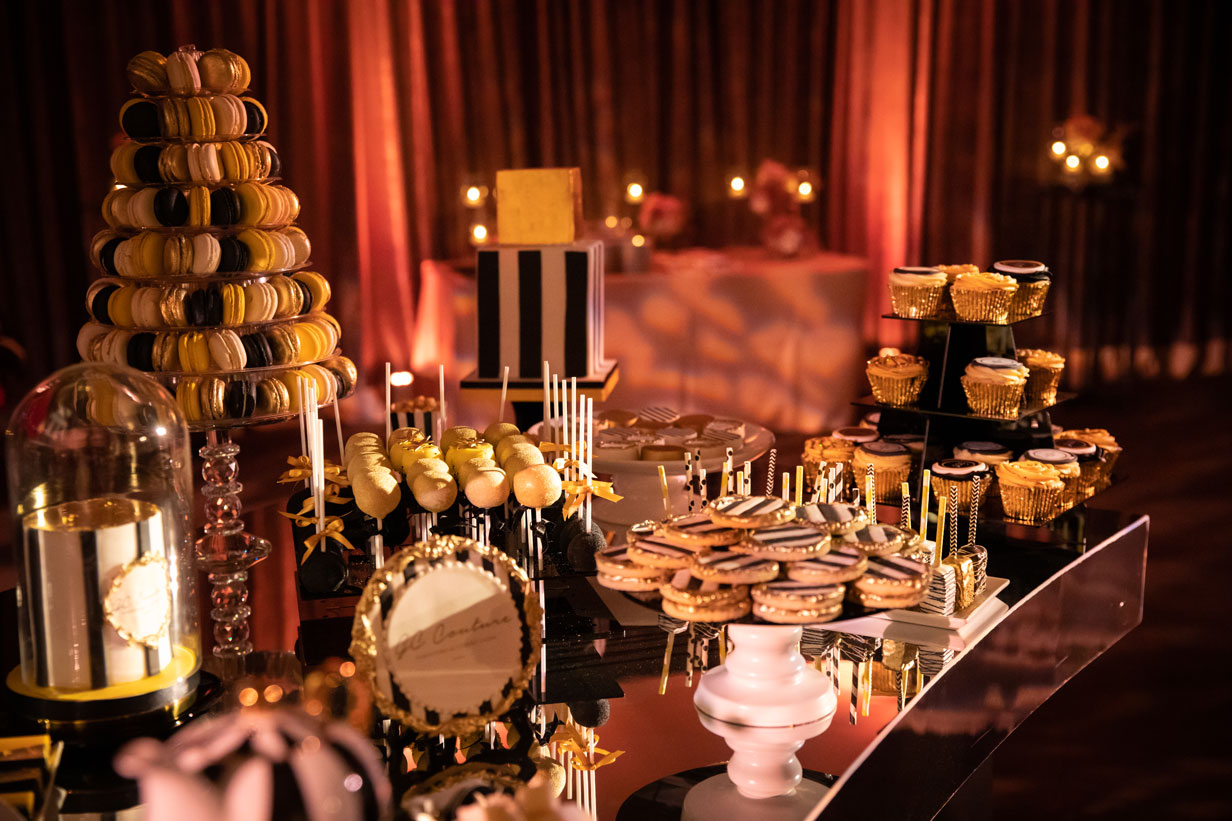 art deco black white and gold luxury dessert table including cookies, macarons cupcakes