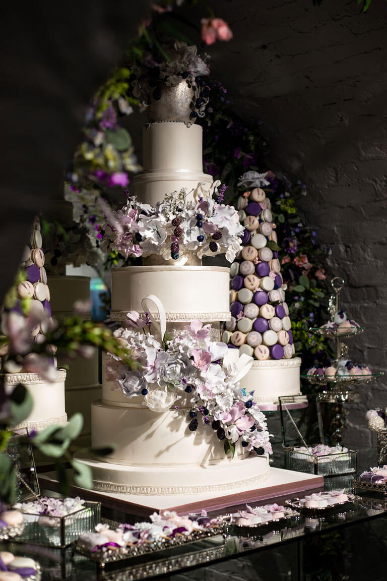 a bespoke luxury wedding cake and sweet treats displayed on a table in london