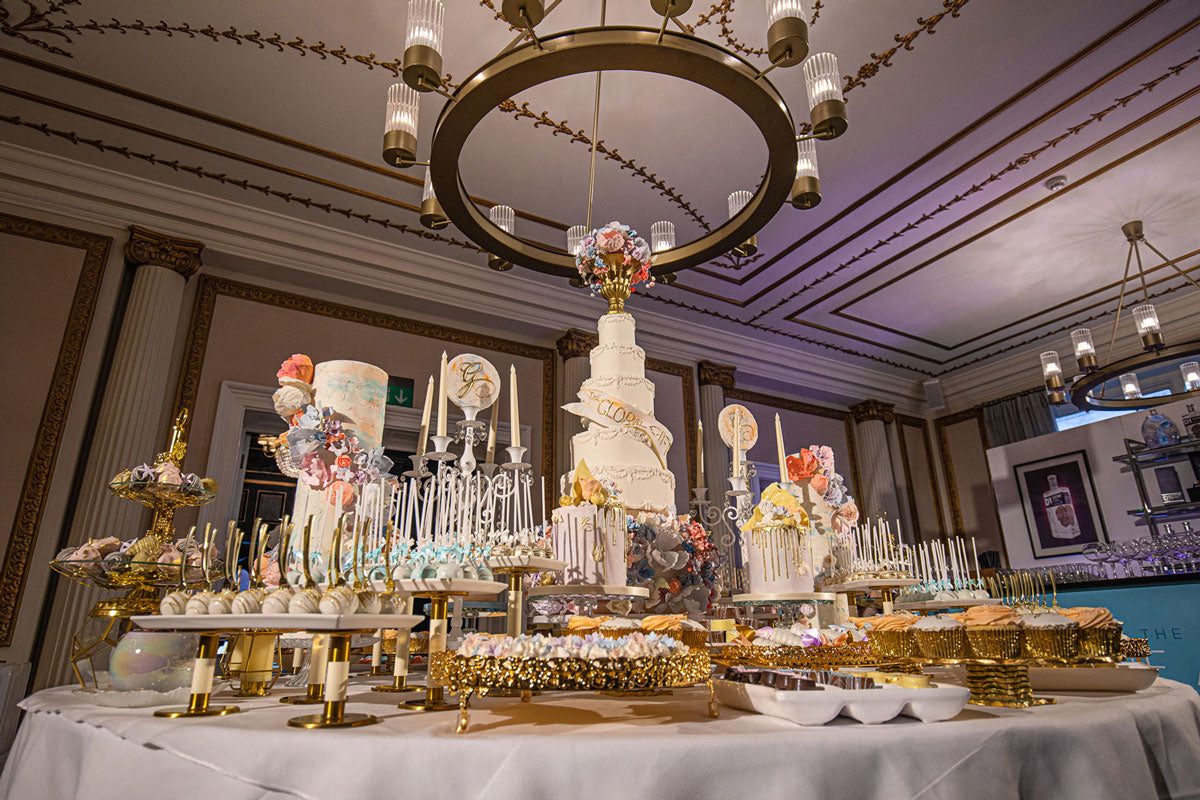 a large circular table full of cakes and desserts in a five star hotel