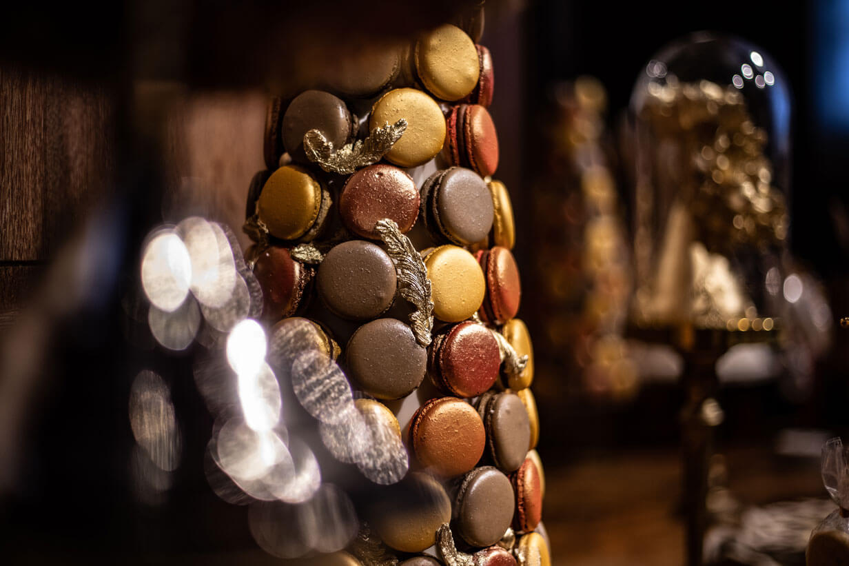 a brown gold and orange macaron tower on a desert table display in london