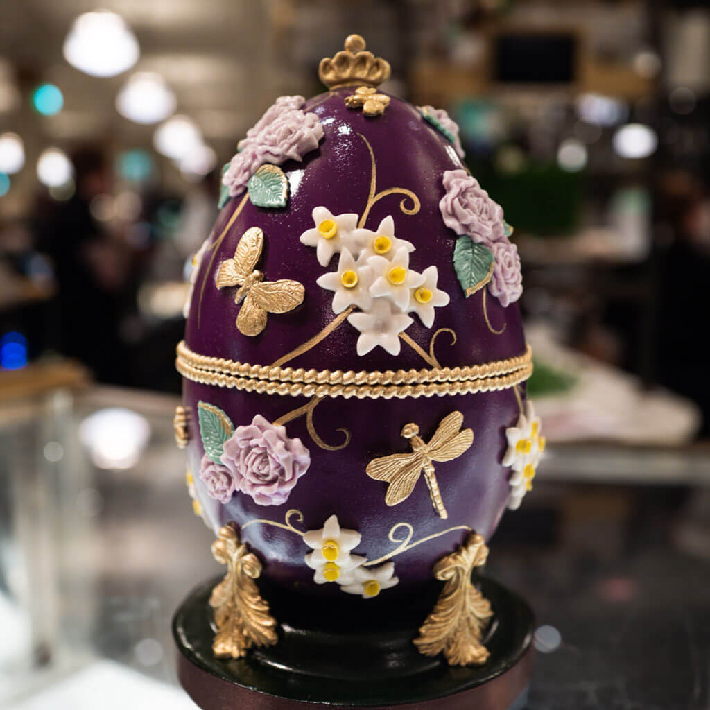 an edible purple cake egg with very ornate details like faberge