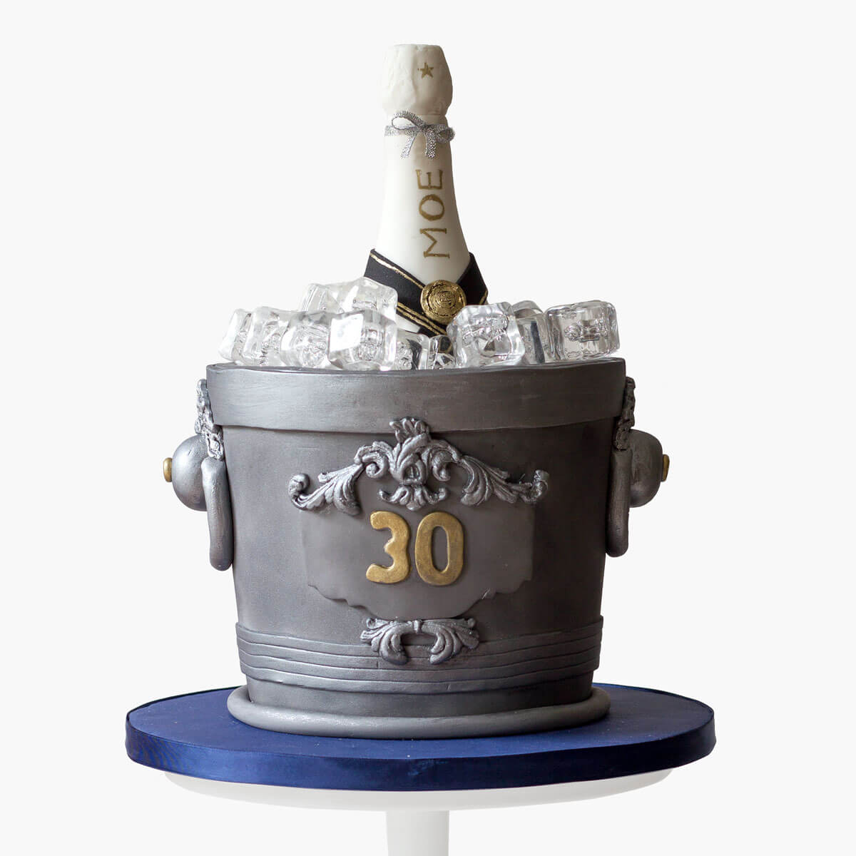 Custom-desiged champagne bucket cake with a non edible champagne bottle, realistic ice cubes and a metalic silver finish