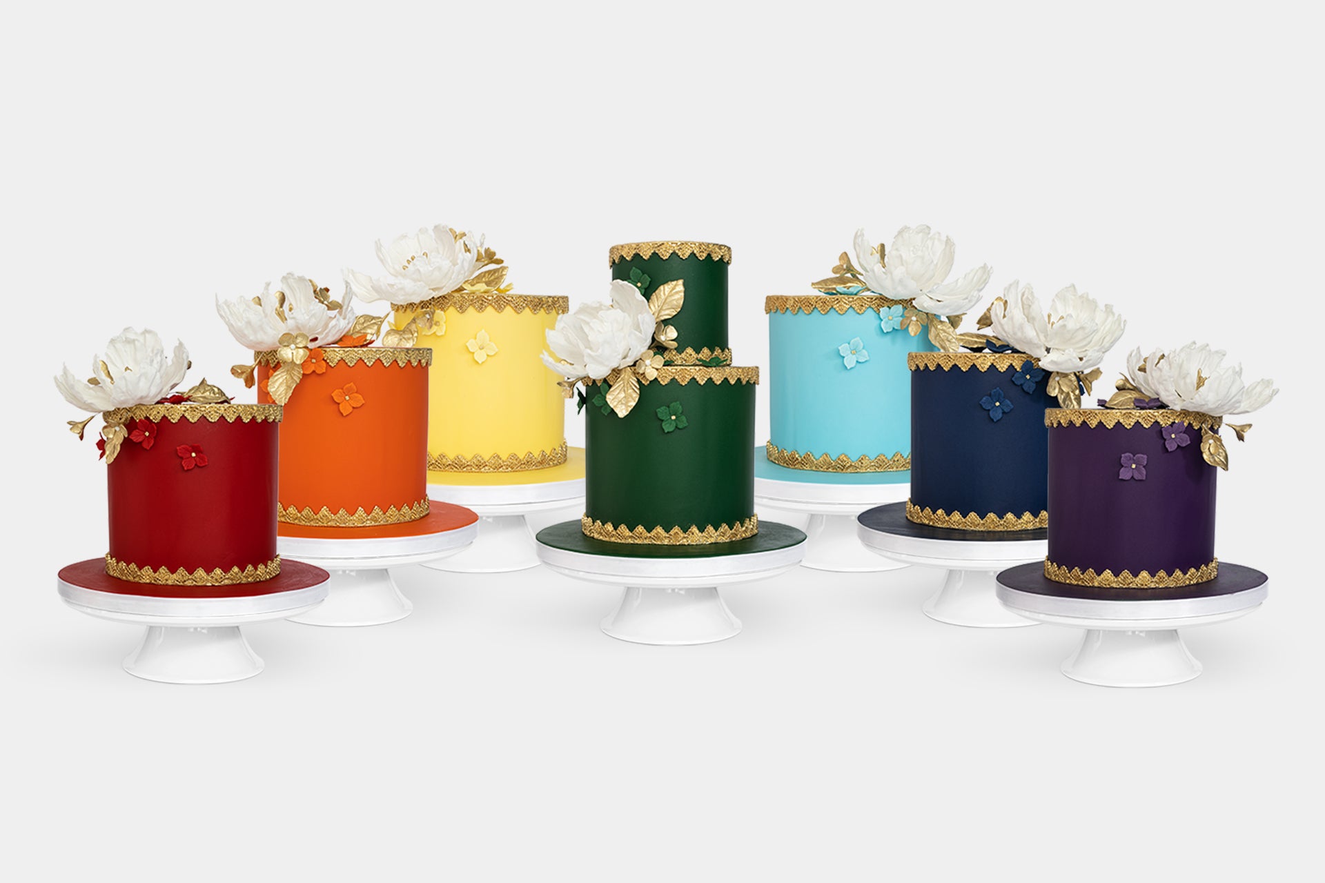 Luxurious vibrant coloured fondant cakes with gold lace detailing, large white peony with gold leaves topper