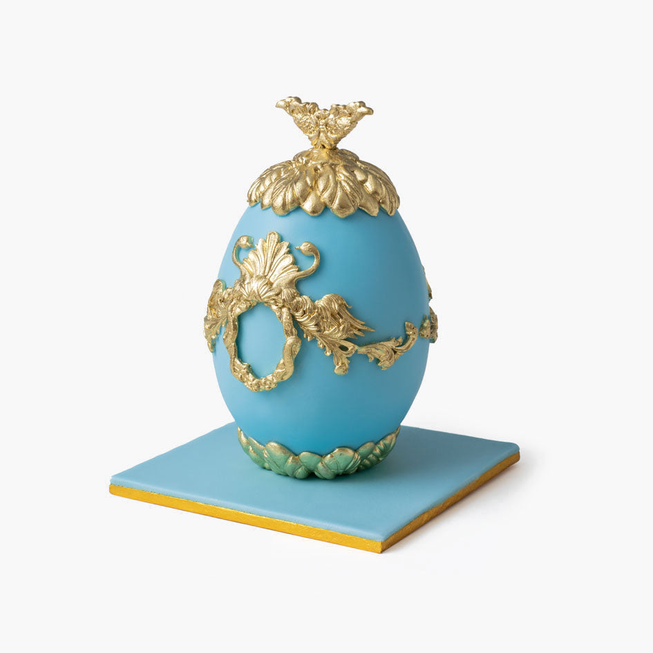 Blue Faberge cake egg with ornate gold decorations and crown