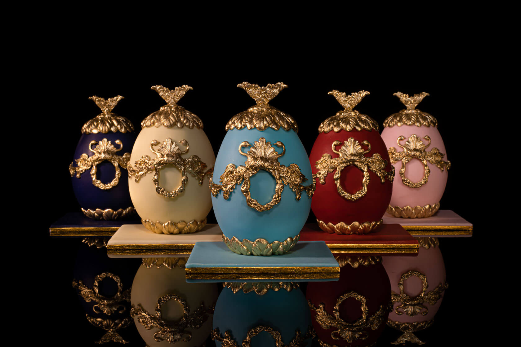 Faberge cake eggs with ornate gold decorations and crown