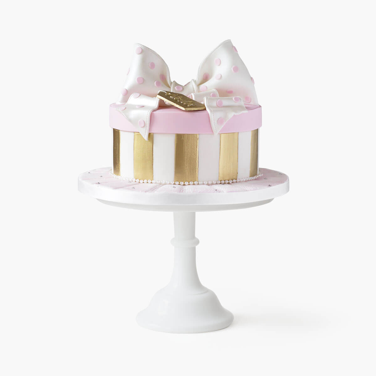 Cake shaped like a gift box complete with lid, bow and gold tag on top