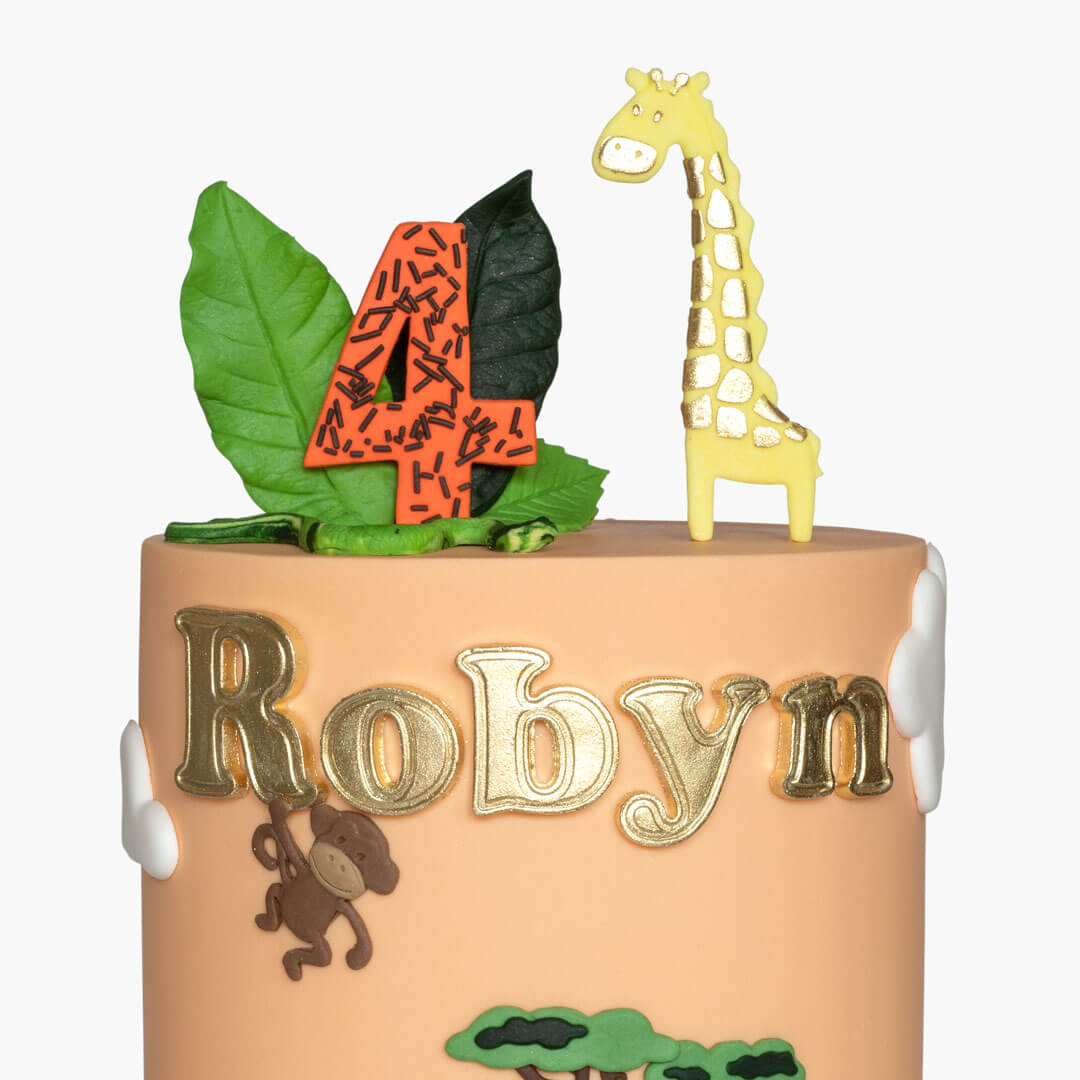 Fun childrens animal birthday cake featuring a colourful safari scene with jungle animals, personalised with age and name handpainted in gold