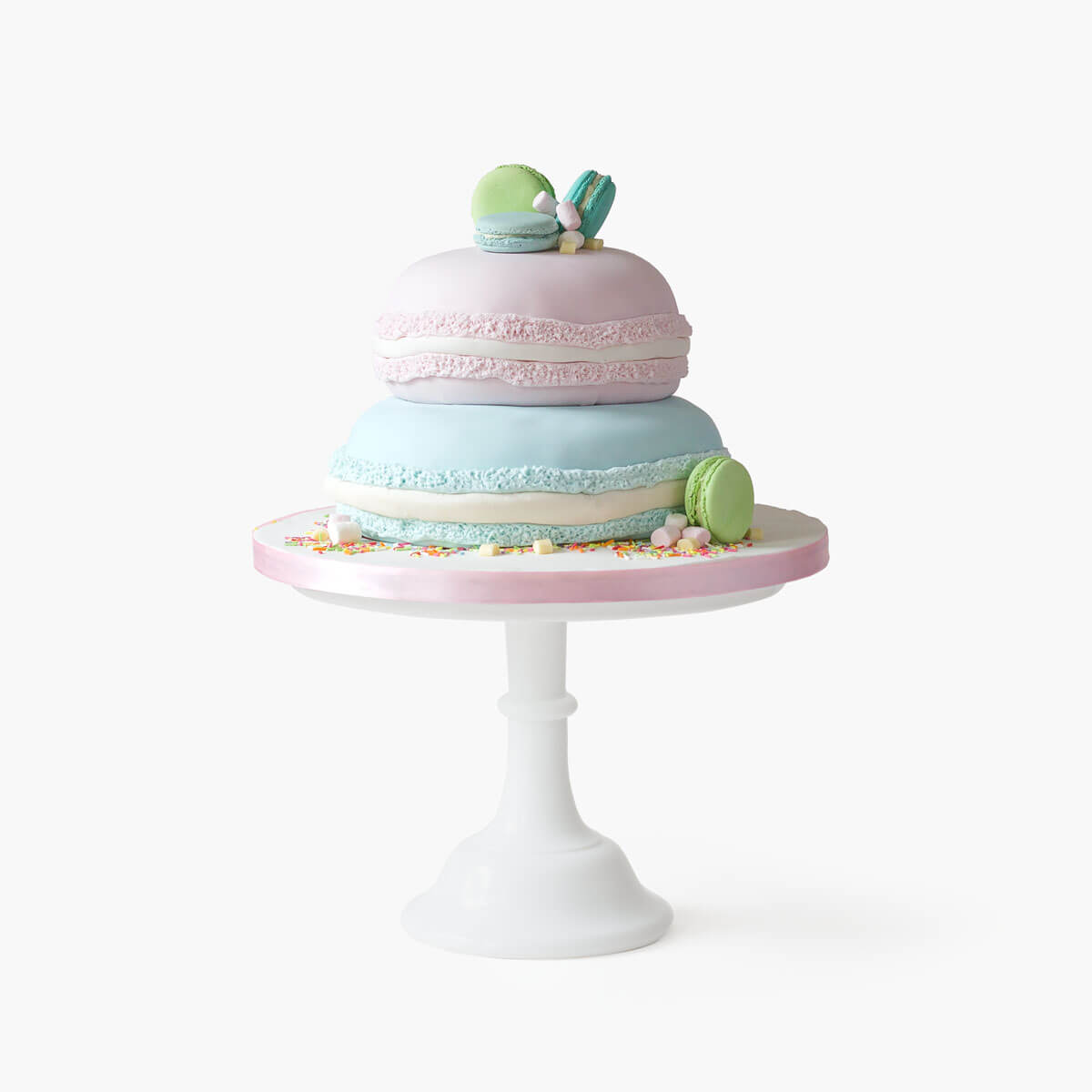 Two tiered pink and blue macaron themed cake with actual macarons as toppers amd side decorations