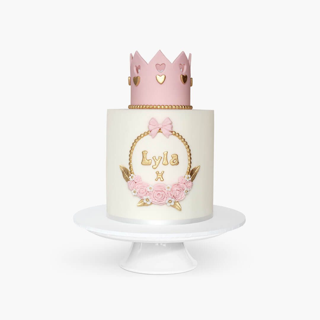 Children's birthday cake with white fondant icing a cute pink & gold princess crown on tope, personalised with name at the front