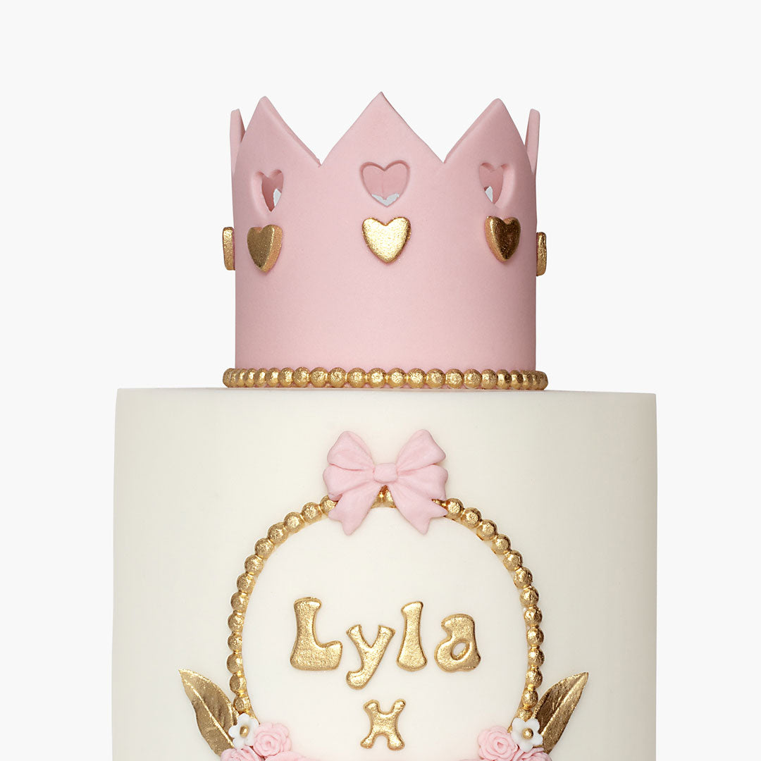 Children's birthday cake with white fondant icing a cute pink & gold princess crown on tope, personalised with name at the front